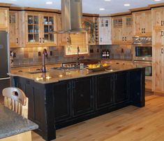 a large kitchen with an island in the middle and wooden cabinets on both sides, along with stainless steel appliances