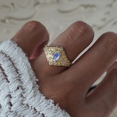 Step into a realm of ethereal beauty with our enchanting "Moonstone Moon Diamond" ring. This ring features a magical natural moonstone with a blue sheen when light reflects on it. Handcrafted in your choice of 14K and 18K gold. Only one available. All orders come in our Tippy Taste ring box. This ring is handmade and designed in NYC. 14K or 18K solid gold Natural oval moonstone. 6*4mm 12 Natural round diamonds. SI clarity, GH color, 0.11ct total carat weight 1.1mm width, 1.5mm thick band ** Tippy Taste Heirloom Collection is made to order. Please allow 3-4 week turnaround time. Shipping:Domestic: Free shippingInternational: Free shippingAll orders are insured, come with tracking, and with signature requirements. Please review our international shipping. Customization:- Interested in custom Moon Diamond Ring, Magical Jewelry, Oval Ring, Ethereal Beauty, Ring Box, Bird Feathers, Wedding Inspo, Moonstone, Round Diamonds