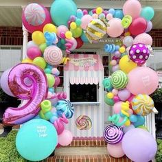 a candy shop with balloons and streamers on the front door for a 2nd birthday party