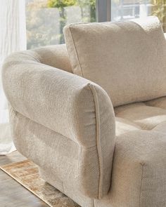 a beige chair sitting in front of a window