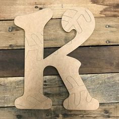 the letter k is made out of cardboard and sits on top of a wooden surface