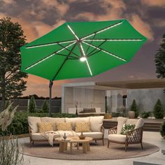 an outdoor living area with green umbrella and furniture