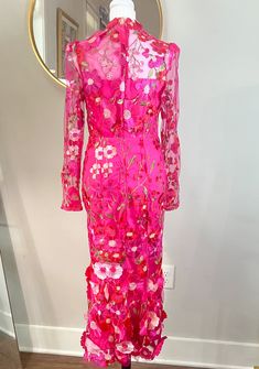 a woman's pink dress on display in front of a mirror