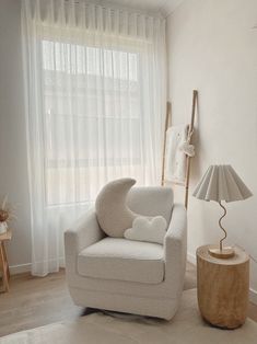 a white chair sitting next to a window in a living room