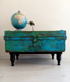 an old trunk with a globe on top