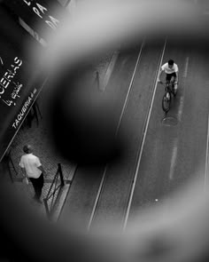 a man riding a bike down a street next to a tall building