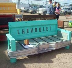 a blue bench sitting in the middle of a parking lot next to other cars and trucks