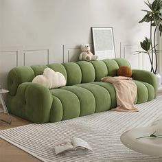 a green couch sitting on top of a white rug