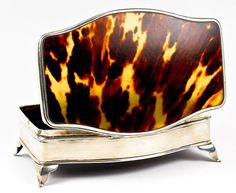 a brown and black animal print dish on a silver stand