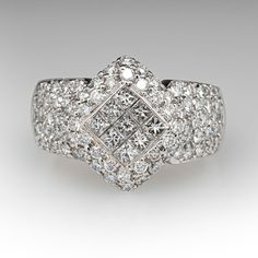 This captivating ring is centered with nine (9), invisible set, princess cut diamonds that are bordered with thirty-six (36), bead set, round brilliant cut diamonds. The shoulders of the ring are each accented with twenty-two (22), bead set, round brilliant cut diamonds. The ring measures 14.3mm at the top, rises 5.4mm above the finger, tapering to 4.4mm wide and 1.2mm thick at the base of the shank. This ring is currently a size 5.75. Luxury Cluster Diamond Ring With Single Cut Diamonds, Luxury Baguette Cut Cluster Ring With Single Cut Diamonds, Luxury Cluster Cut Diamond Ring, Luxury Cluster Diamond Ring, Luxury Cluster-cut Diamond Ring, Elegant Square Cut Pave Setting Jewelry, Luxury Radiant Cut Diamond Ring With Single Cut Diamonds, Elegant Square Cut Jewelry With Pave Setting, Luxury White Square Cut Diamond Ring