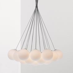 a chandelier with five white balls hanging from it's center and four on each side