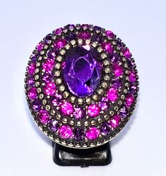 F A B, 1970's OVERSIZED LADIES DRESS COCKTAIL RING UK SIZE O WITH PURPLE SET CRYSTALS IN VARIOUS TONES IN A LAYERD FASHION   WITH ONE CENTRAL LARGE PURPLE PASTE STONE  SET ON A POLISED SPLIT BRASS BAND  WITH A GOLDEN TONE  PRE OWNED BUT IN A VERY GOOD VINTAGE CONDITION  VERY SMALL SIGNES OF USE BUT NOTHING THAT STICKS OUT  NO STONES MISSING  IF YOU LOVE VINTAGE BRIGHT STATEMENT ITEMS , THIS IS FOR YOU  SIZE  UK SIZE O OVAL HEAD  4 X 3 CM  WEIGHT  20 GRAMS POSTAGE FREE Purple Set, Brass Band, Lovely Necklace, Stick It Out, Cocktail Ring, Stone Settings, Cocktail Rings, Rings Statement, Vintage 70s