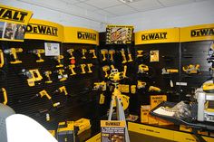 there are many tools on display in the shop and one is yellow with black accents