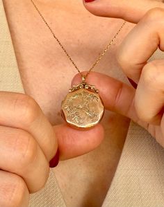 This beautifully crafted round locket with octagonal-shaped edges, dating to the Edwardian era (c. 1910), features intricate engravings on both sides. The design includes floral and leaf motifs, along with a delicately etched bird, likely a swallow, symbolizing love, loyalty, and return. The top of the locket is adorned with an ornate, bow-like decoration. Crafted in 9ct yellow gold (marked) on the front and back, the locket's inner frames and hinges are reinforced with brass for durability-- a Vintage Locket Necklace, Locket Design, Gold Locket Necklace, Vintage Locket, The Edwardian Era, Antique Locket, Round Locket, Vintage Lockets, Gold Locket