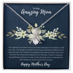 a mother's day necklace with flowers on the front and back of it in a gift box