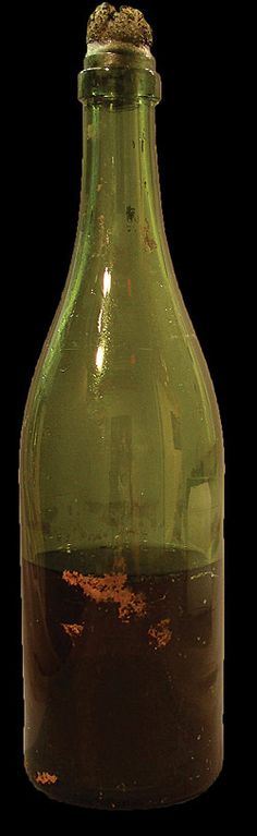 a green glass bottle filled with brown liquid