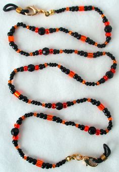 You'll never leave your glasses behind using this black & orange beaded eyeglass chain! 25" in length, made with glass beads, beading cord, metal lobster clasps, and adjustable rubber holders. Lobster clasps make it easy to change the rubber holders, and an extra pair of holders included with every purchase. This black & orange beaded eyeglass chain will arrive in a gift box, ready to give as a present or to keep and store. Back to Beaded Eyeglass Chains Crow Jewelry, Beaded Eyeglass Chain, Handmade Eyewear, Beading Cord, Halloween Beads, Eyeglass Chain, Black Halloween, Eyewear Accessories, Czech Beads