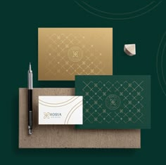 business cards and pen on top of a cork board with gold foil lettering that reads horia