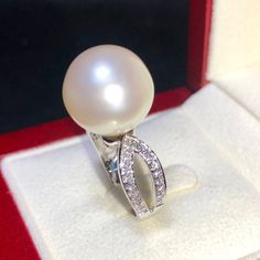 Genuine SOUTH SEA PEARL, absolutely natural color and luster, 14 mm in size, surrounded by 38 pieces of hand-set E/VVS superb quality diamonds, weighting at 0.47 carat. Set in handcrafted, one of a kind 18K solid white gold ring, weighting at 6.0 grams. The pearl is naturally cultured from South Australia Sea, its luster is extra fine, AA+ grade with 95% clean surface. SUGGESTED RETAIL PRICE: $9,800 The ring is hand crafted to a high standard and is NOT mass machine produced and is brand new con Formal White Pear-shaped Diamond Ring, Luxury White Pear Shaped Rings, Elegant Silver Rings With High Luster, Elegant Pear-shaped Diamond Ring Gift, White Pear-shaped Diamond Ring As Gift, Elegant Pear-shaped Diamond White Ring, Elegant White Pear-shaped Ring, White Gold Pearl Ring With High Luster Diamonds, Luxury White Pear-shaped Diamond Ring