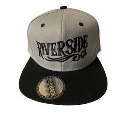 a white and black baseball cap with the riverside logo on it's front side