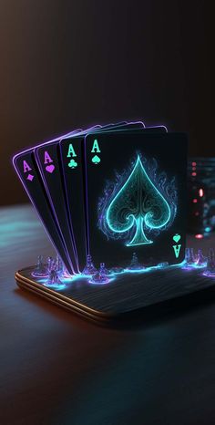 four neon playing cards sitting on top of a laptop