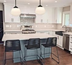 a kitchen with white cabinets and black bar stools