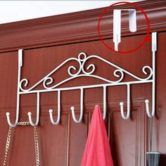 a coat rack with two umbrellas hanging from it's hooks and a pink towel on the hanger