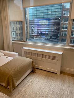 a bedroom with a large window overlooking the city