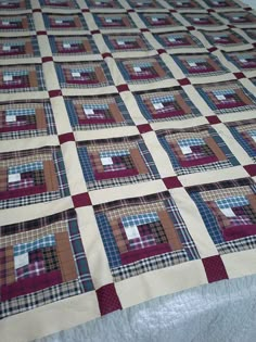 a bed with a quilt on it that is made to look like squares and rectangles