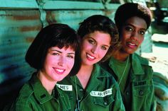 three women in green uniforms are smiling for the camera