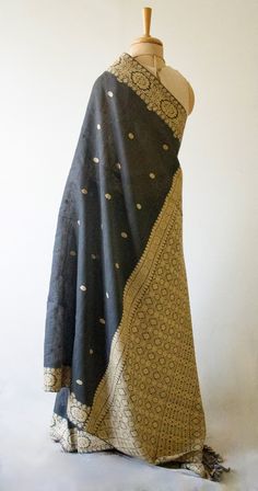 A genuine handloom product from the looms of Assam, India. The Sari has mulberry silk in the warp and eri silk in the weft and the interweaving motifs Muga Spun Silk and natural colour Eri Silk yarns. The mulberry silk in this case is raw mulberry silk . Known locally as 'kesa pat ' or 'nooni' . It has slight crispness and less sheen than the finer mulberry silk yarns.  Muga Spun is derived from the waste of muga silk cocoons and yarns. It doesn't have the bright golden sheen of the filament mug Gold Silk Dupatta With Woven Motifs, Festive Black Dupatta With Weaving Work, Ceremonial Raw Silk Dupatta With Woven Motifs, Bohemian Traditional Wear With Weaving Work In Silk, Bohemian Traditional Silk Wear With Weaving Work, Black Chanderi Dupatta With Weaving Work, Traditional Black Silk Scarf, Black Handloom Slub Silk Dupatta, Bohemian Chanderi Dupatta With Weaving Work