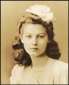 an old photo of a woman with a flower in her hair