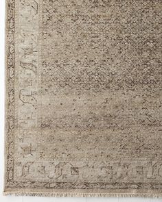 an antique rug with faded edges and fringes on the bottom, in grey tones