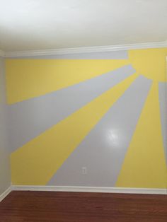 an empty room with yellow and gray paint on the walls, wood floors and hard wood flooring