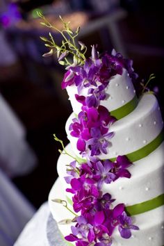 a wedding cake with purple flowers on top