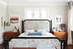 a bedroom with a bed, nightstands and pictures on the wall above it's headboard