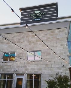 the front of a building with string lights hanging from it