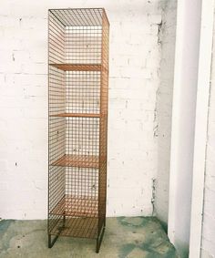 a tall metal shelf sitting next to a white brick wall