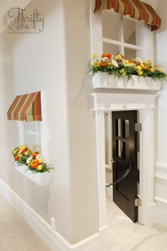 a white fireplace with flowers in the window boxes