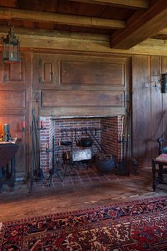 an old fashioned fireplace in a wood paneled room