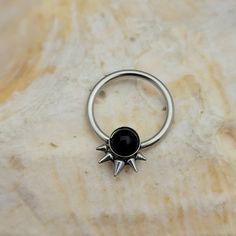 a black stone ring sitting on top of a marble slab