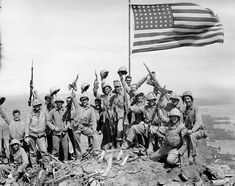 an old black and white photo of people carrying flags