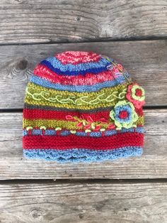 a colorful knitted hat sitting on top of a wooden table