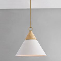 a white and gold colored light hanging from a ceiling fixture in a room with gray walls