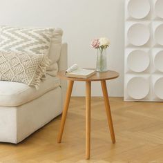 a living room with a couch, table and vase filled with flowers on the side