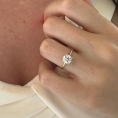 a woman's hand with a diamond ring on it