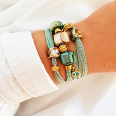 Women's bracelet in turquoise, beige and gold tones. This bohemian-style bracelet with a chic touch is made with a turquoise, aquamarine, light blue cotton ribbon that wraps around your wrist three times and is tied at the back. It is decorated with several charms of different styles, Greek porcelain beads, golden charms and two hanging light points. This bracelet has a bohemian touch but is very elegant and distinguished. Give your look a modern and youthful point with chic airs. -------------- Turquoise Bracelet Jewelry, Turquoise Bracelet Fashion Accessory, Turquoise Fashion Bracelet, Elegant Turquoise Bracelets, Bohemian Turquoise Bracelets, Adjustable Green Crystal Bohemian Bracelet, Gold Bohemian Friendship Bracelets, Bohemian Green Crystal Bracelet For Beach, Handmade Turquoise Bracelets For Fashion