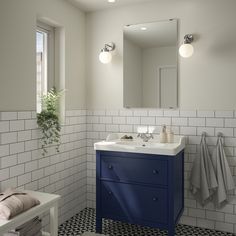 a bathroom with white and blue tile on the floor, sink, mirror and towel rack