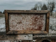 an old wooden frame with brown and white paint