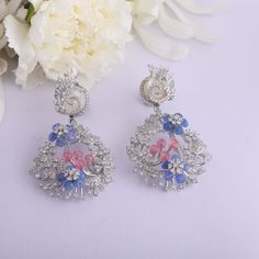 Description : This blooming statement earring is a fusion of opulent CZ stones and colorful beryl beads that showcase the mythical Indian floral motifs depicting the shape of Chaand. Handcrafted on 925 silver by our skilled artisans, these earrings have a royal and timeless look ideal for women who love nature and elegance. Product Information : Metal: 925 Silver with White Rhodium Plating Length: 6cm Stones: Semi precious stones Findings- Push Back Hand Set Fusion Chandelier Drop Earrings, Fusion Style Hand Set Chandelier Drop Earrings, Fusion Style Gemstone Chandelier Earrings For Wedding, Silver Gemstone Danglers For Wedding, Sterling Silver Fusion Chandelier Earrings, Fusion Style Hand Set Chandelier Earrings As Gift, Fusion Style Sterling Silver Chandelier Earrings, Elegant Fusion Style Drop Bridal Earrings, Fusion Style Elegant Bridal Drop Earrings